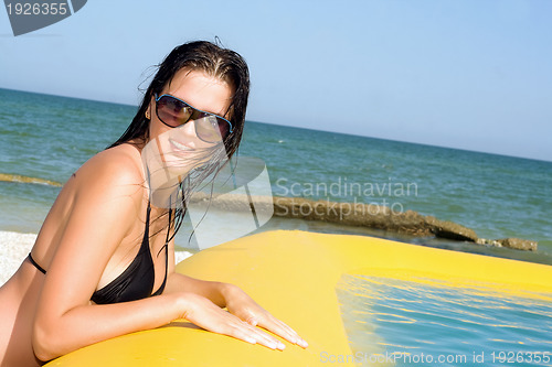 Image of young woman by the yellow pool