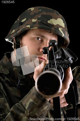 Image of Ready soldier aiming a rifle in studio