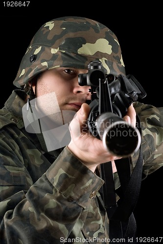 Image of Alerted soldier pointing m16 in studio