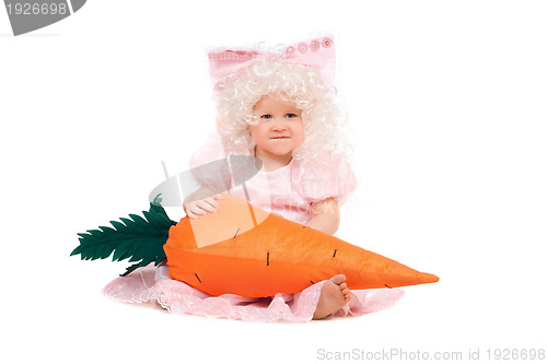 Image of Funny baby girl plays with a carrot