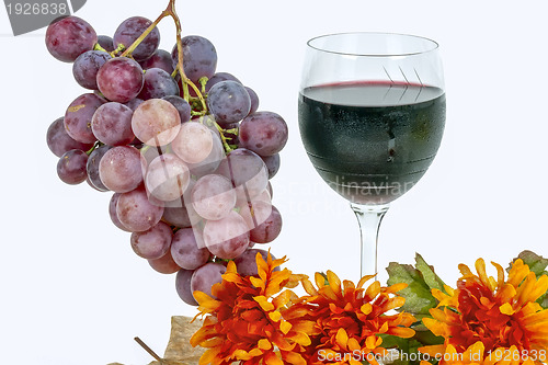 Image of red grapes with a glass of wine