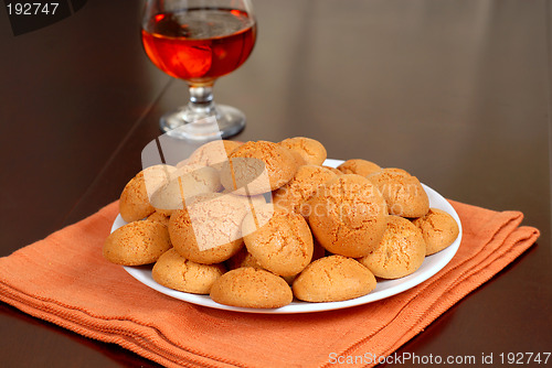 Image of A plate of crisp Amaretti cookies with snifter of Amaretto in ba