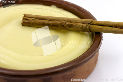 Image of clay bowl, tasty dessert custard and cinnamon