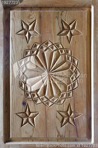 Image of floral tars motifs carved on the old wooden doors.