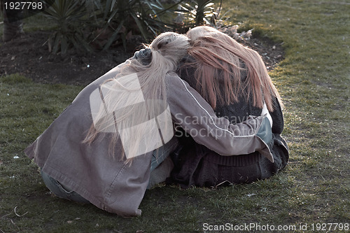 Image of Two young people embracing in a park 
