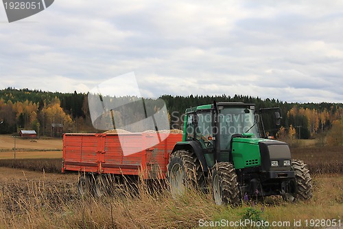 Image of Green Tractor and Agricultural Trailer by Bean Field