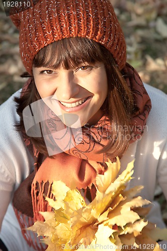 Image of woman with autumn orange leaves