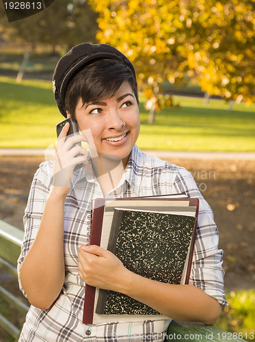 Image of Mixed Race Female Student Holding Books and Talking on Phone