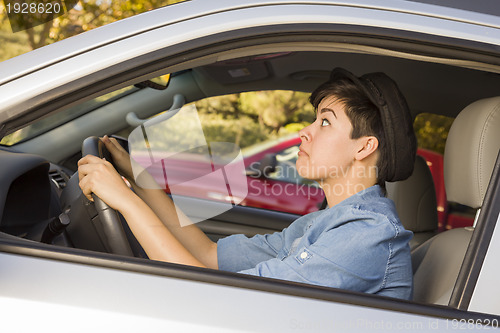 Image of Stressed Mixed Race Woman Driving in Car and Traffic