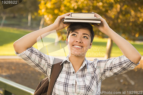 Image of Mixed Race Female Student Holding Books on Her Head