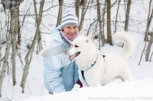 Image of The woman with a dog in winter on walk