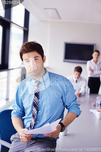 Image of business man  on a meeting in offce with colleagues in backgroun