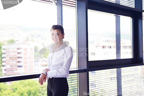 Image of business woman with her staff in background at office