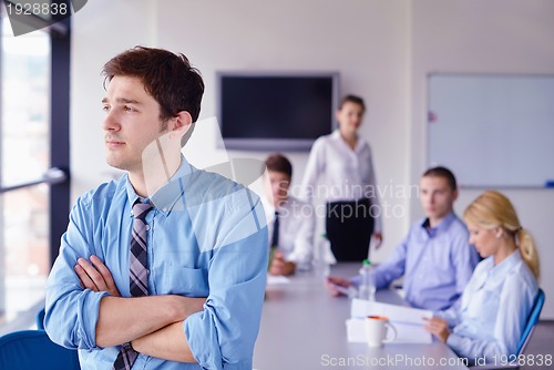 Image of business man  on a meeting in offce with colleagues in backgroun