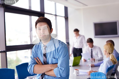 Image of business man  on a meeting in offce with colleagues in backgroun