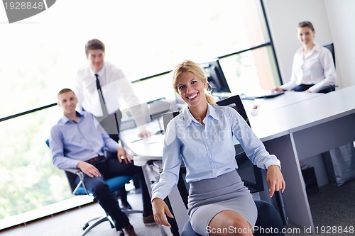 Image of business woman with her staff in background at office