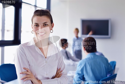 Image of business woman with her staff in background at office
