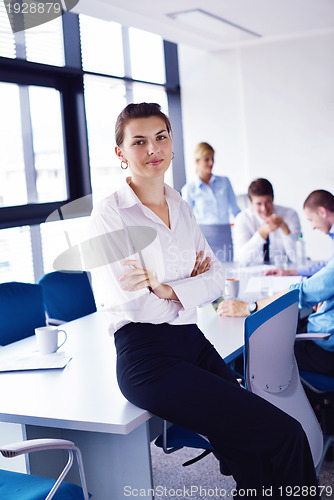 Image of business woman with her staff in background at office