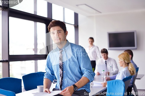 Image of business man  on a meeting in offce with colleagues in backgroun