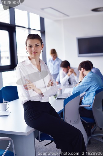 Image of business woman with her staff in background at office