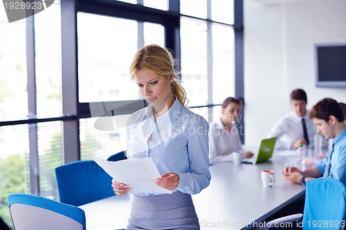 Image of business woman with her staff in background at office