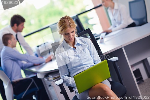 Image of business woman with her staff in background at office
