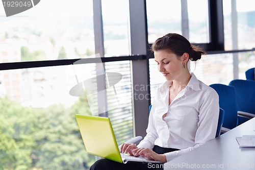 Image of business woman with her staff in background at office