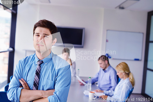 Image of business man  on a meeting in offce with colleagues in backgroun