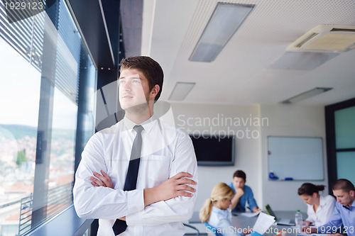 Image of business man  on a meeting in offce with colleagues in backgroun