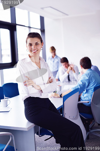 Image of business woman with her staff in background at office