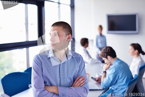 Image of business man  on a meeting in offce with colleagues in backgroun