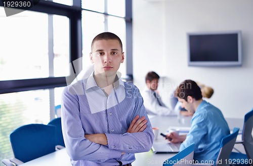 Image of business man  on a meeting in offce with colleagues in backgroun