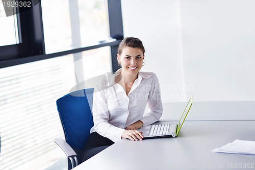 Image of business woman with her staff in background at office