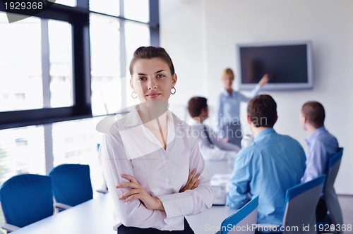 Image of business woman with her staff in background at office