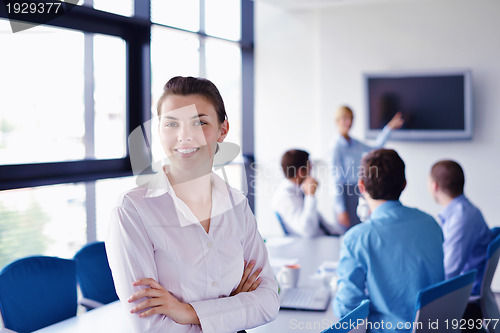 Image of business woman with her staff in background at office