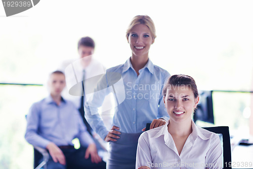 Image of business woman with her staff in background at office