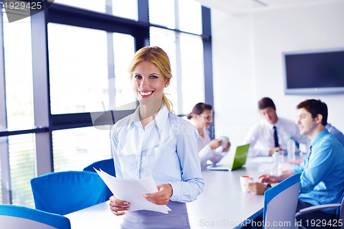 Image of business woman with her staff in background at office