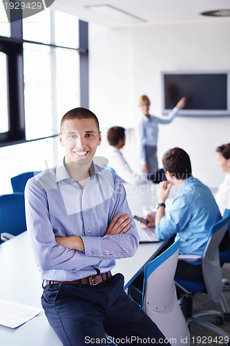 Image of business man  on a meeting in offce with colleagues in backgroun