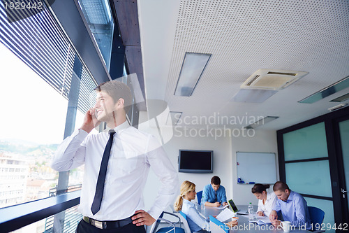 Image of business man  on a meeting in offce with colleagues in backgroun