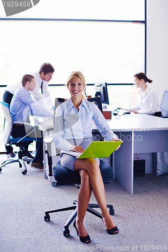 Image of business woman with her staff in background at office