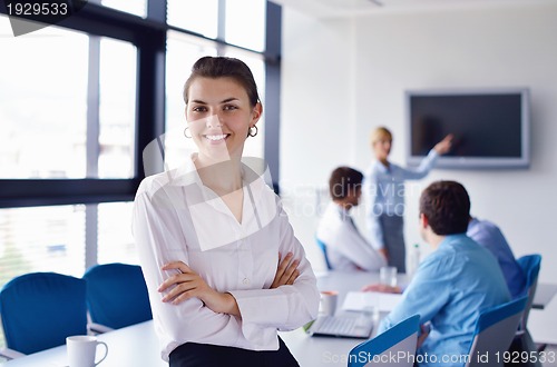 Image of business woman with her staff in background at office