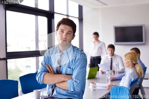 Image of business man  on a meeting in offce with colleagues in backgroun