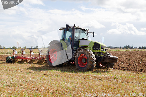 Image of tractor plowing agricultural field autumn 