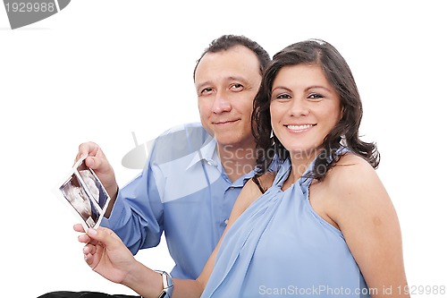 Image of Attractive hispanic young pregnant couple expecting a child hold