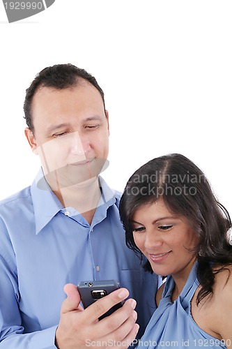 Image of Couple looking at a cell phone and smiling isolated on a white b