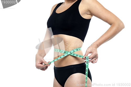 Image of Fit woman measuring her waist, cropped image