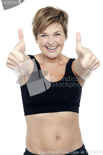Image of Excited attractive fit lady showing double thumbs up