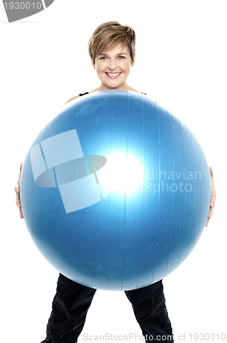 Image of Charming woman holding big blue fitness ball