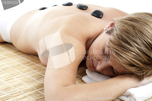 Image of Woman getting a spa treatment with stone massage