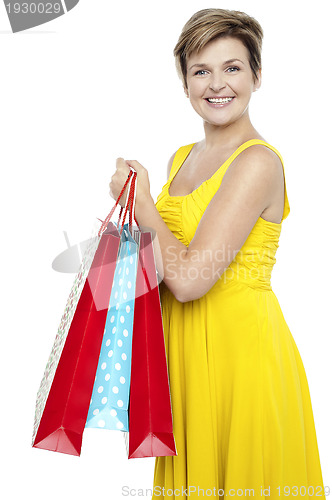 Image of Pretty woman holding colorful shopping bags